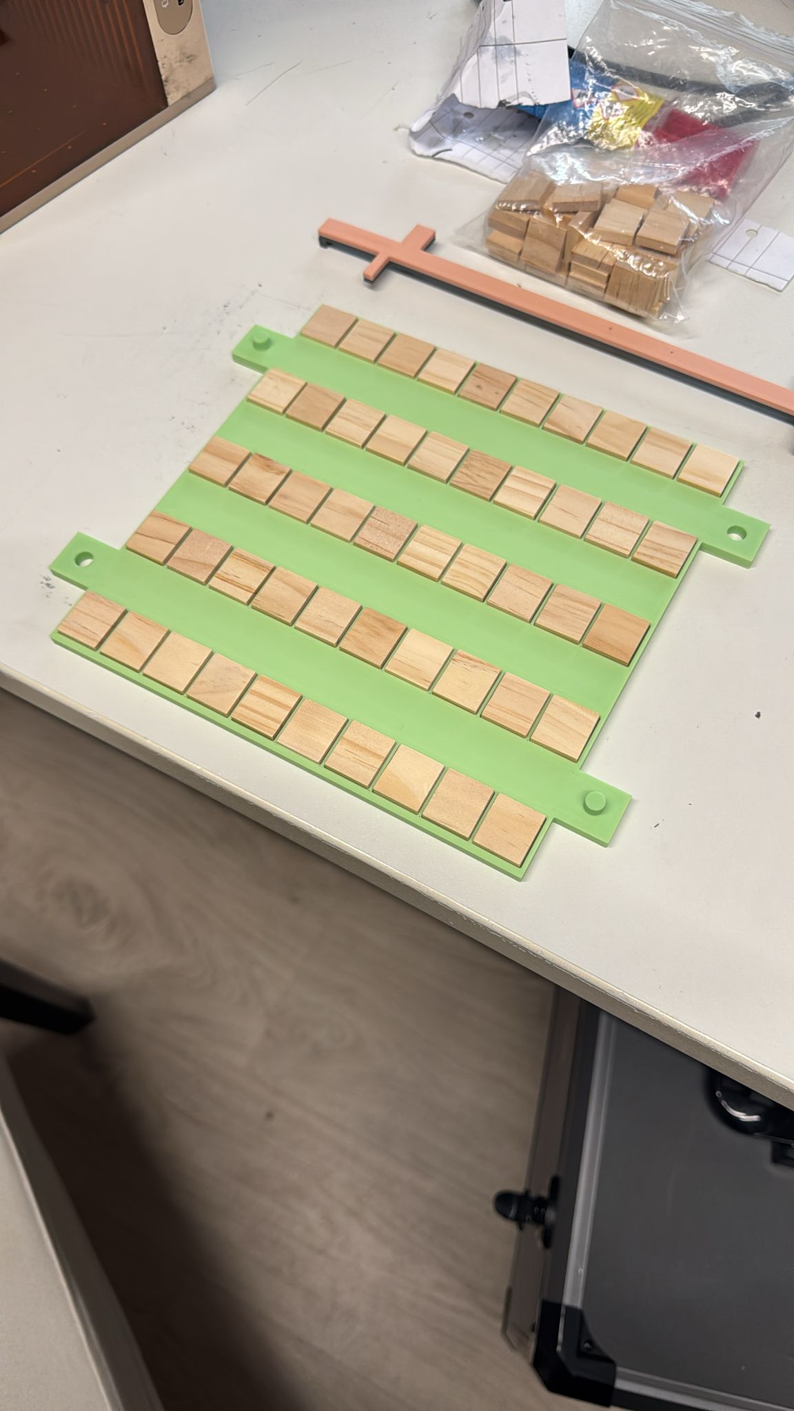3D-gedrucktes Jig hält eine ganze Charge Holz-Scrabble-Steine in Reihen bereit zum Lasern